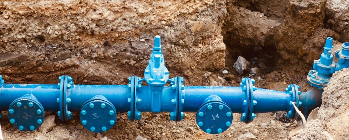 a blue pipe laying on top of a pile of dirt