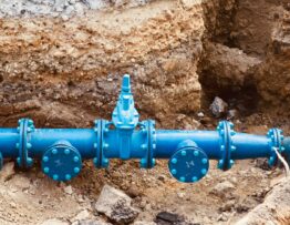 a blue pipe laying on top of a pile of dirt