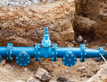 a blue pipe laying on top of a pile of dirt